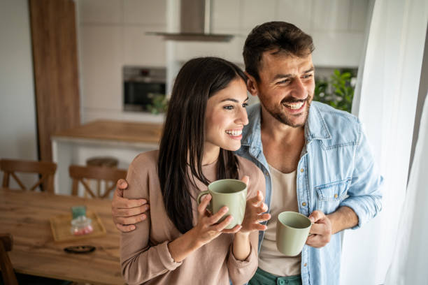 istock Young couple looking through the window in their home 2156915320