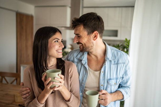 istock Young couple looking through the window in their home 2156915333