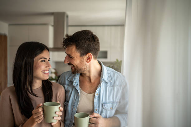 istock Young couple looking through the window in their home 2156915497