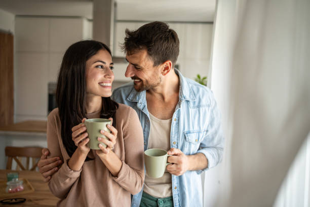 istock Young couple looking through the window in their home 2156915675