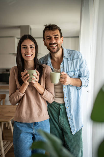 istock Young couple looking through the window in their home 2156916744
