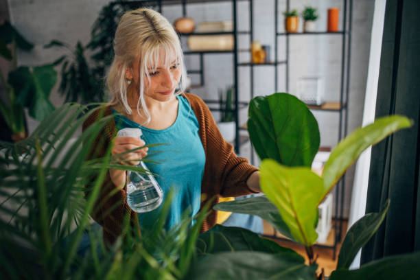 istock Blond girl watering plants 2156916798