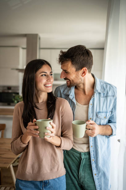 istock Young couple looking through the window in their home 2156917071