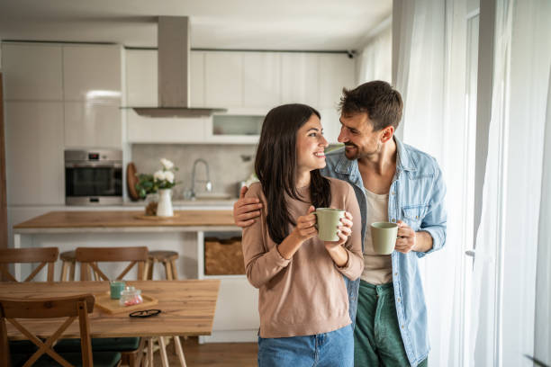 istock Young couple looking through the window in their home 2156917697