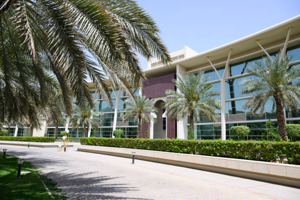 Green landscaped gardens and modern further education building facade.