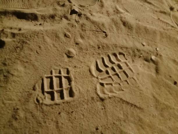 istock shoe prints left in the sand 2156919726