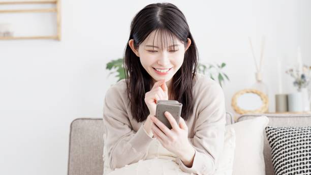 istock Woman looking at smartphone in living room 2156920004