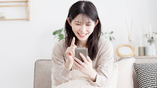 istock Woman looking at smartphone in living room 2156920005