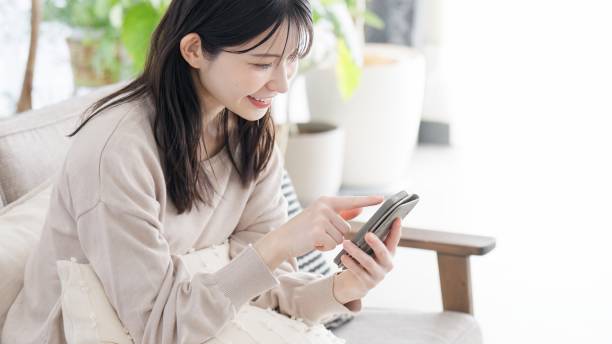 istock Woman looking at smartphone in living room 2156920007