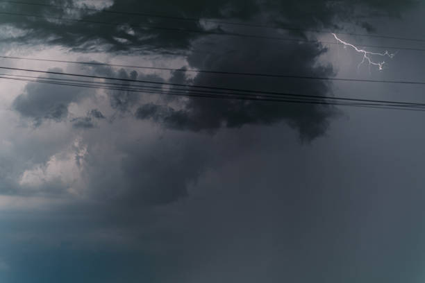 Stormy sky. Thunderstorm clouds with the discharges of lightning, the lumen of the sun. Dark blue, dark gray sky before the rain. Weather concept