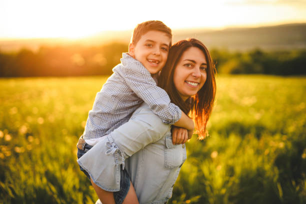 istock Beautiful mother with son on sunset field 2156922224