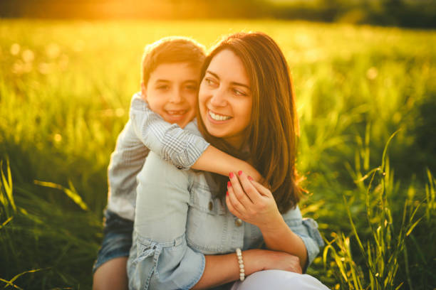 istock Beautiful mother with son on sunset field 2156922227