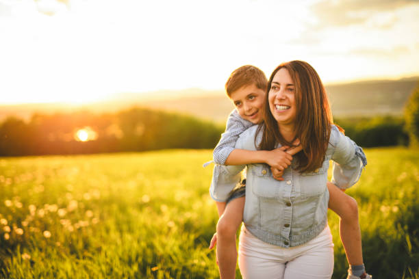 istock Beautiful mother with son on sunset field 2156922229