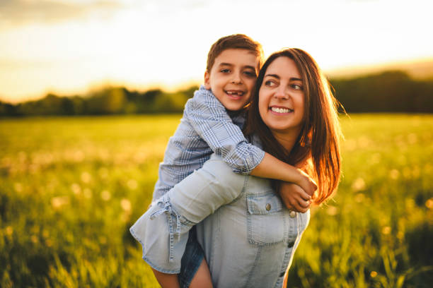 istock Beautiful mother with son on sunset field 2156922239