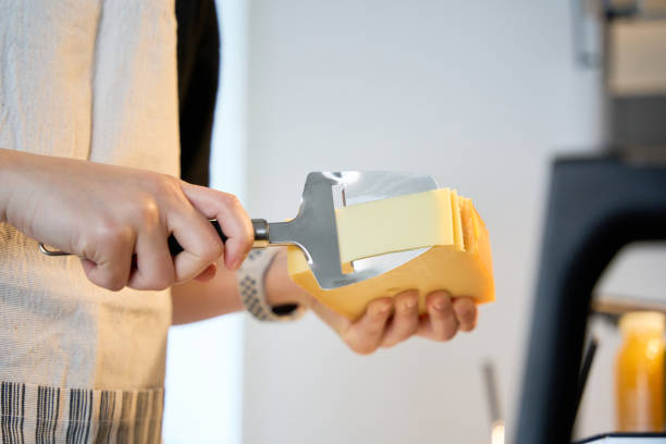 Young beautiful woman is cutting cheese