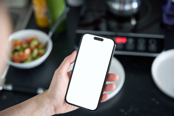 istock Close-up Young beautiful woman is using the phone in the kitchen 2156929981