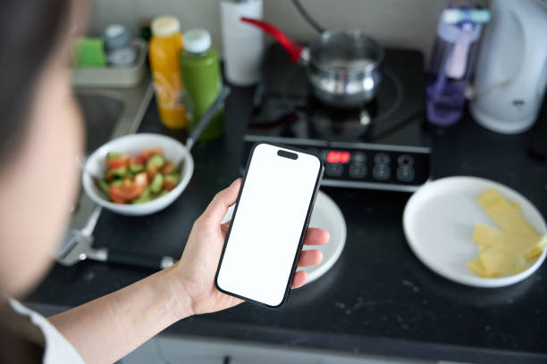 istock Close-up Young beautiful woman is using the phone in the kitchen 2156929989
