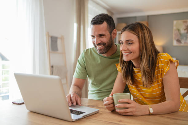 istock Couple at home making a reservation online using their laptop 2156930107