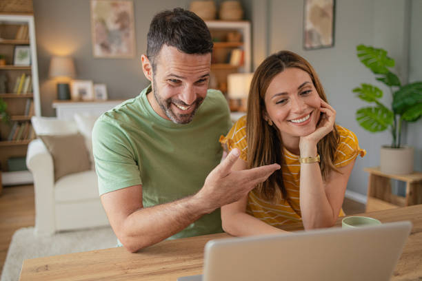 istock Couple at home making a reservation online using their laptop 2156930279