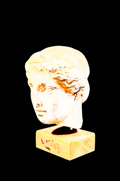 A statue of a woman's head is on a pedestal. The statue is white and has a brownish tint. The statue is of a woman with a head and shoulders, but no arms or legs