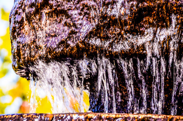 A large rock with water dripping from it. The image has a calm and peaceful mood
