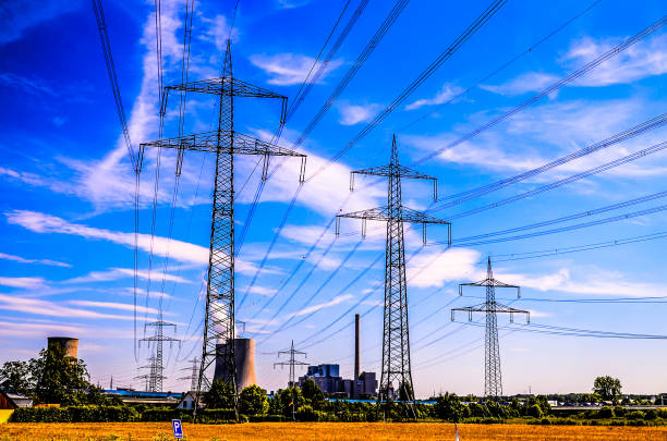 A power line tower with a power line running from it. The sky is blue with some clouds
