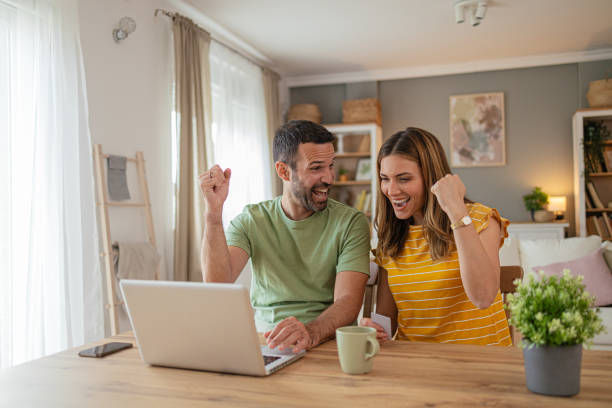 istock Happy couple at home booking a trip online 2156930813