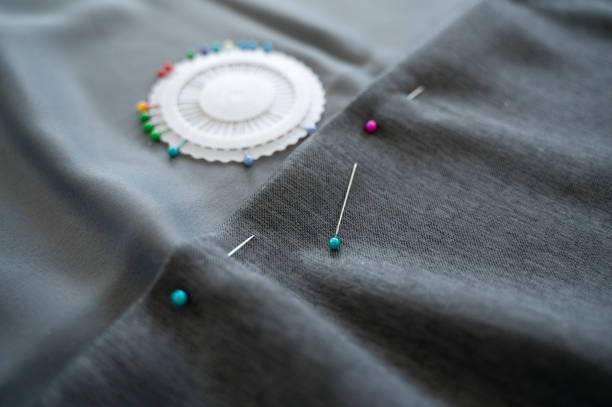 istock Sewing pins are lying in case on fabric being hemmed 2156931889