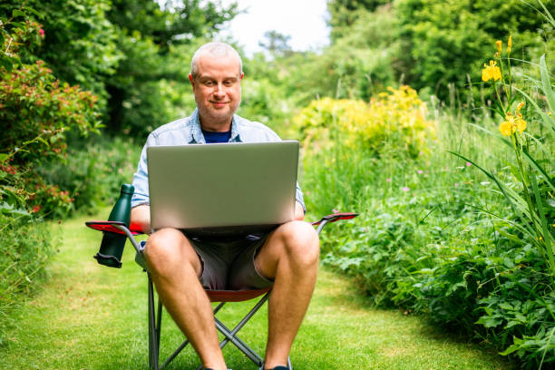 istock Digital nomad working using laptop outdoors in beautiful garden 2156933916