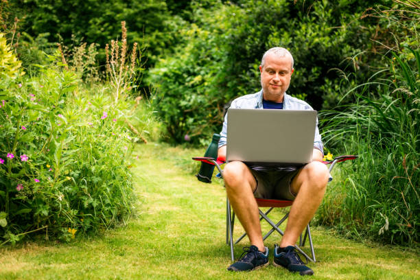 istock Digital nomad working using laptop outdoors in beautiful garden 2156933924