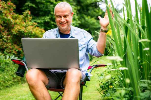 istock Digital nomad on video conference call outdoors in beautiful garden 2156933929
