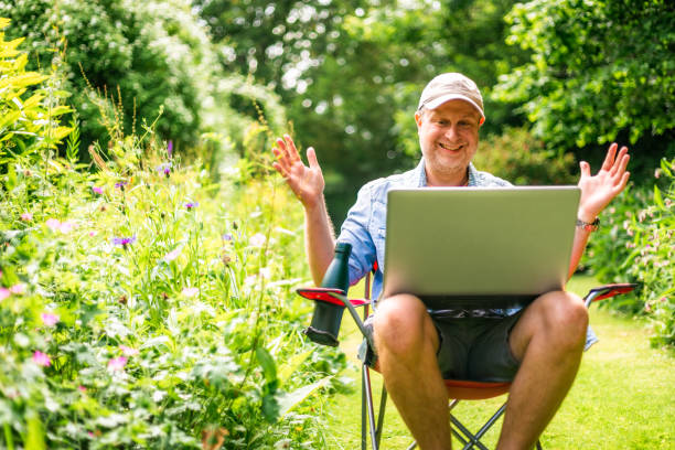 istock Digital nomad on video conference call outdoors in beautiful garden 2156933978