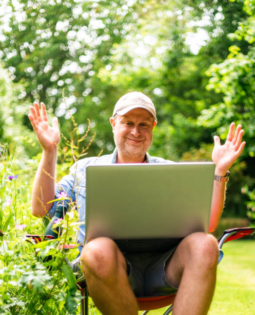 istock Digital nomad on video conference call outdoors in beautiful garden 2156934010