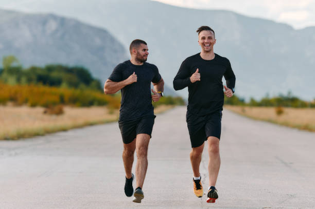 istock Two Friends Jogging Together on a Beautiful Sunny Day 2156935976