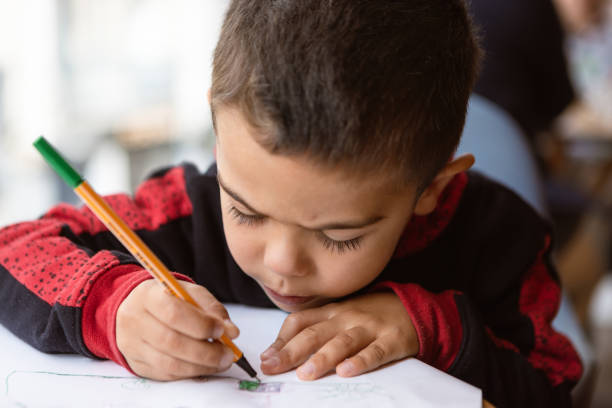 Quiet Concentration of a Young Boy Drawing