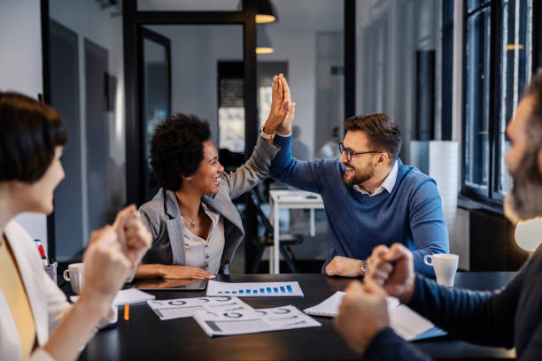 istock A multicultural businesspeople giving high five while while coworkers cheering and celebrating. 2156938163