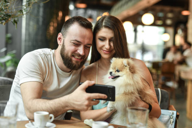 istock Smiling Couple Taking Selfie With Pet Pomeranian 2156938288