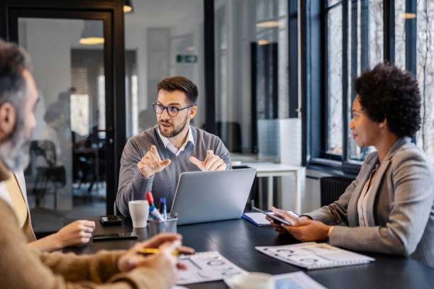istock A businessman is debating project with his interracial team at boardroom. 2156938338