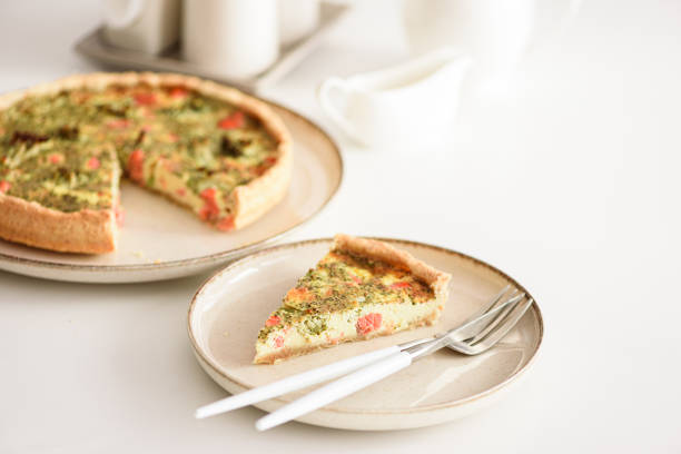 French quiche lauren with salmon, cheese and broccoli on white table. Soft focus