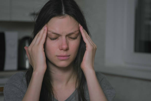 istock Woman with headache in the kitchen at night. Insomnia and depression. 2156941530