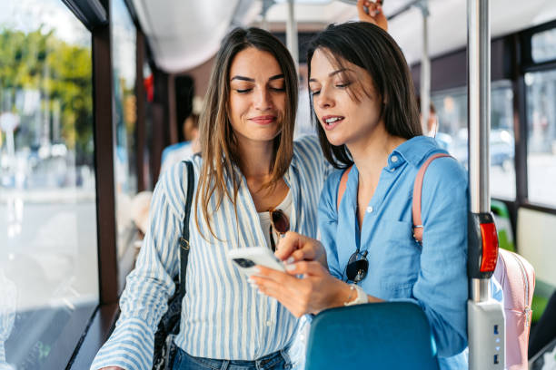 istock Two Female Friends Using Phone While Riding In A Bus In Palma De Mallorca In Spain 2156941745