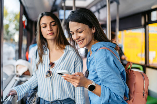 istock Two Female Friends Using Phone While Riding In A Bus In Palma De Mallorca In Spain 2156941889