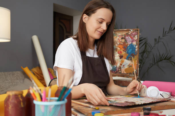 istock Creative Caucasian painter is working on a new art piece in her workshop drawing textures with a palette painting an oil picture with inspiration in her studio 2156944283