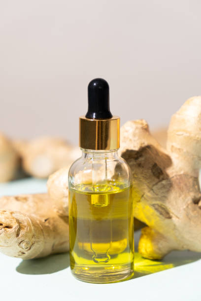 istock Natural ginger oil in glass bottle among ginger root 2156944649