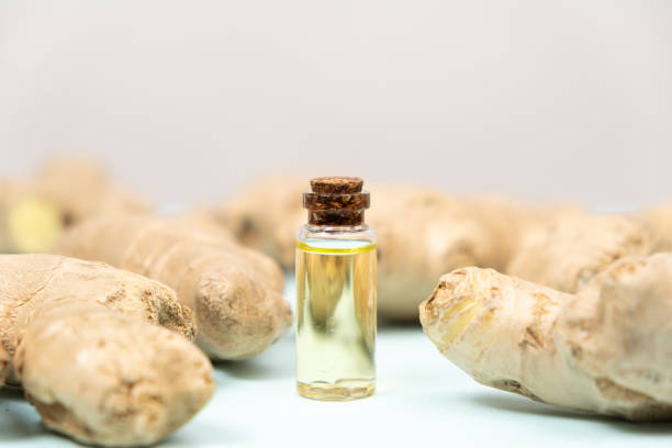istock Natural ginger oil in glass bottle among ginger root 2156944705