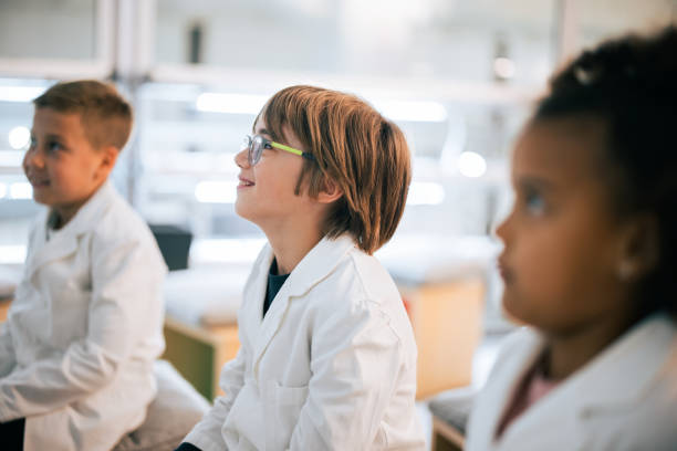 istock Children in Science Class Wearing Lab Coats and Engaged 2156947156