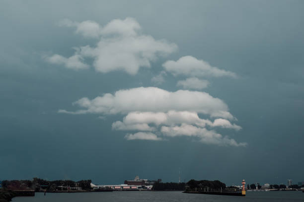 storm sky with white clouds over a harbor entrance on a river