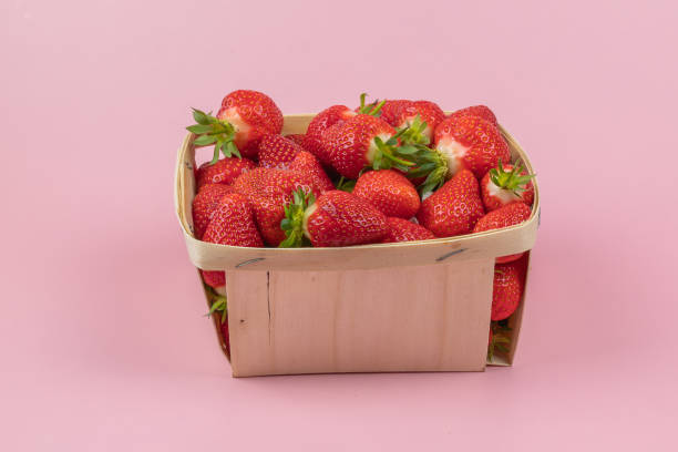 istock punnet of strawberries, close-up, on a pink background 2156955777