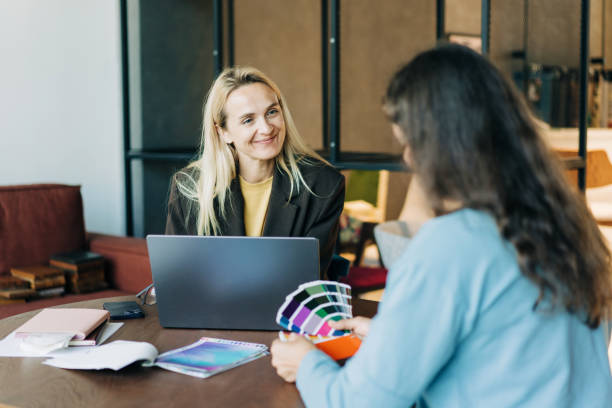 istock Female colleagues working on a design project while sitting at their office desk. 2156956843