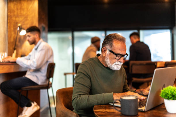 Senior businessman working using laptop at coffee shop